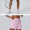 Eine Frau modelliert rosa schnelle, sportliche Shorts und einen Tennisschläger.