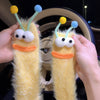 A pair of yellow cartoon expression knit socks with large eyes and orange mouths are being held in a hand inside a car steeri