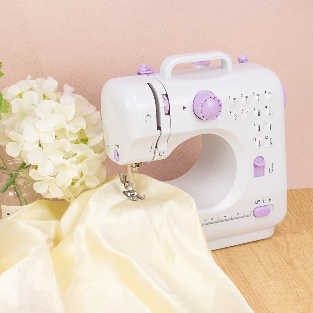 Eine weiße, portable Mini-Nähmaschine mit lila Akzenten neben einem cremefarbenen Stoffstück.
