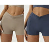 A set of four high-waisted yoga and fitness leggings in pink, beige, navy blue, and black shown on a model.