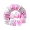 Pink and white satin heatless curling rod headband wrapped in a circular shape