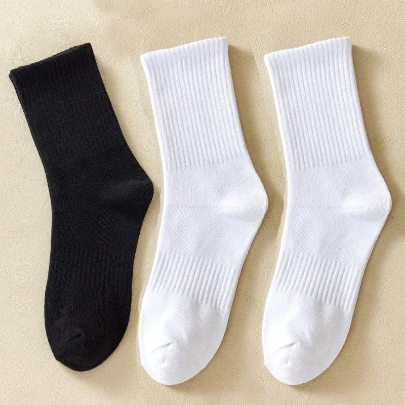 Une paire de chaussettes en coton mélangé côtelées noir et blanc sur un fond clair.