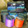 A collection of SOUGA BRAID fishing line spools in various colors including green, black, and purple, resting on a natural su