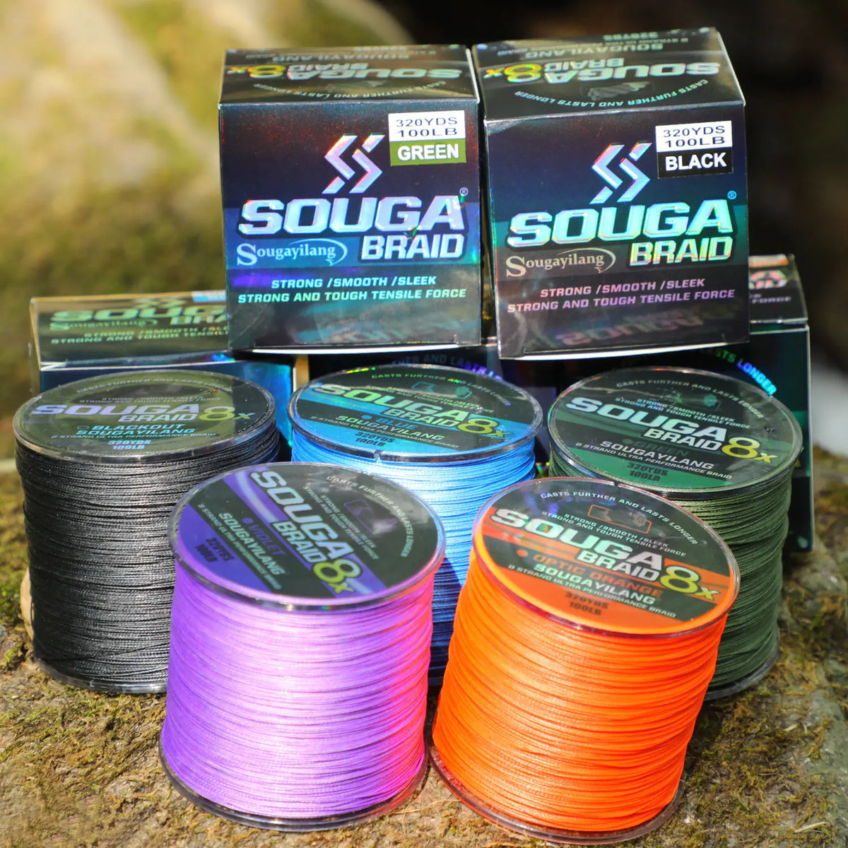 A collection of SOUGA BRAID fishing line spools in various colors including green, black, and purple, resting on a natural su