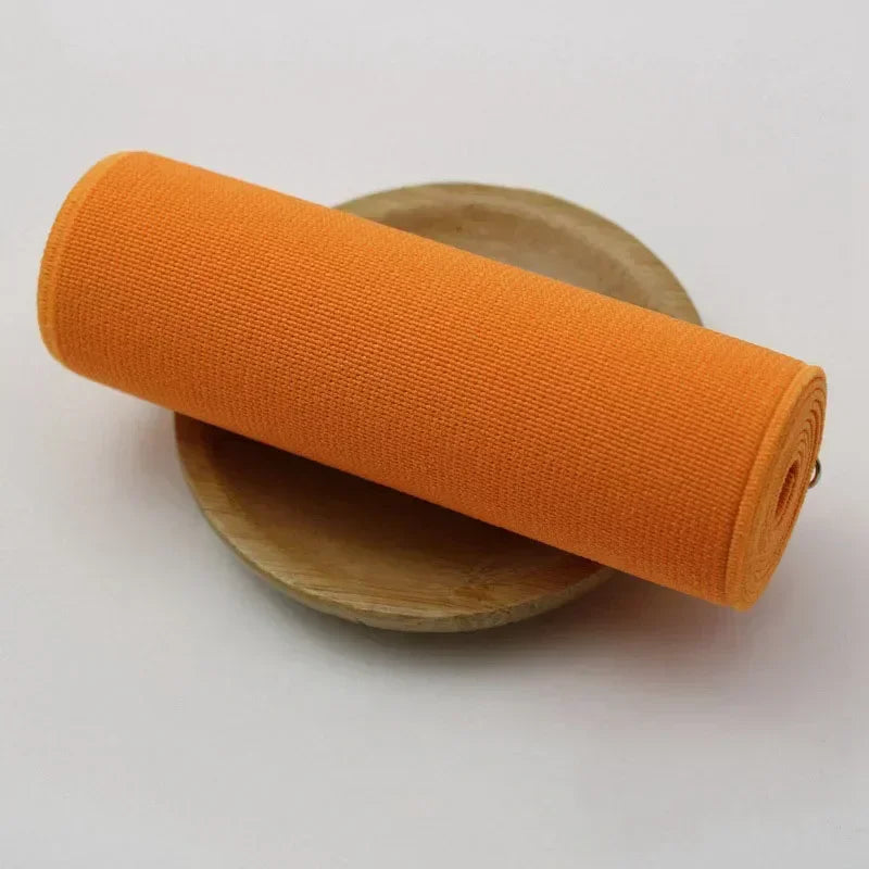 Orange elastic band rolled up on a wooden disc for sewing and decoration