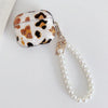 A clear protective case with a leopard print design and a pearl chain attached.