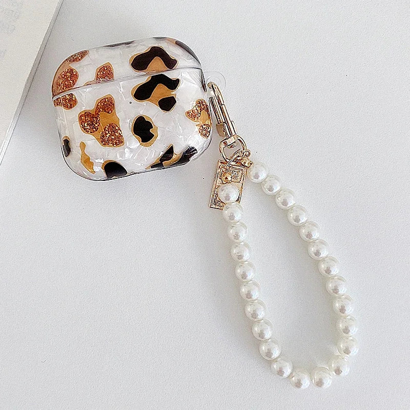 A clear protective case with a leopard print design and a pearl chain attached.