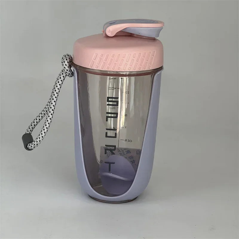 A pink and purple blender shaker bottle with a silicone strap is shown against a light gray background.