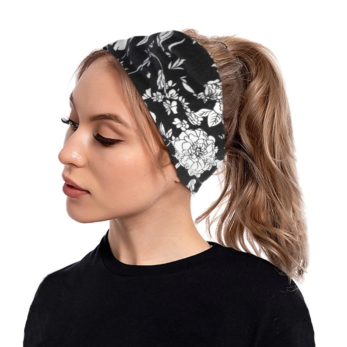 Une femme aux cheveux blonds porte un bandeau floral noir tiré en queue de cheval.