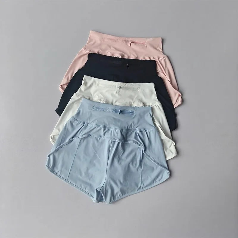 A stack of women's high-waist yoga and fitness shorts in various pastel colors including pink, black, white, and light blue.