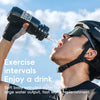A man is drinking water from a sports bottle outdoors under a bright sky.