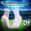 Ein Paar weiße rutschfeste Silikon-Fußballsocken auf einem grünen Feld mit einem Fußball daneben.