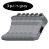 Three pairs of gray performance running socks stacked together.