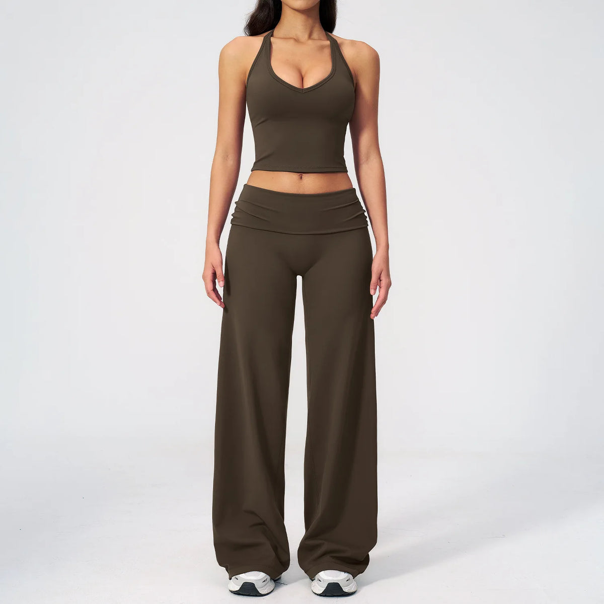 A woman wearing a dark olive green women's premium fitness tracksuit top and matching pants.