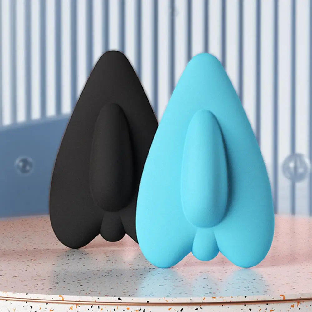 A pair of light blue and black pelvic floor muscle trainers resting on a pink surface.