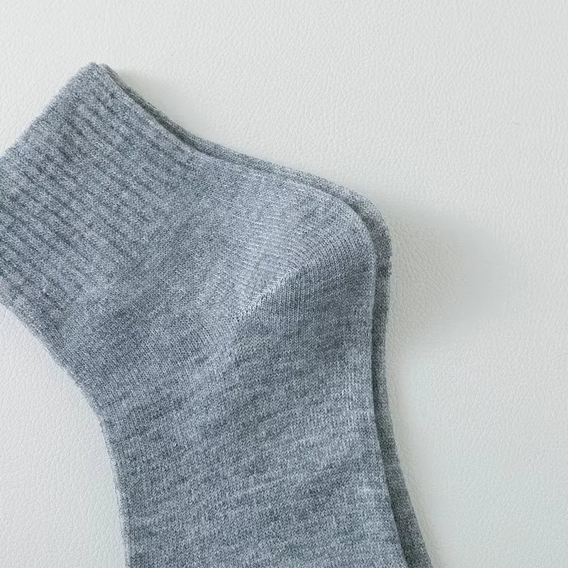Nahaufnahme eines grauen Strick-Fußsockens von der Seite.