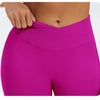 A close-up of a bright magenta seamless high-waist yoga legging worn by a person.