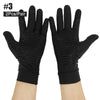 Pair of black copper compression fingerless gloves worn on a hand.