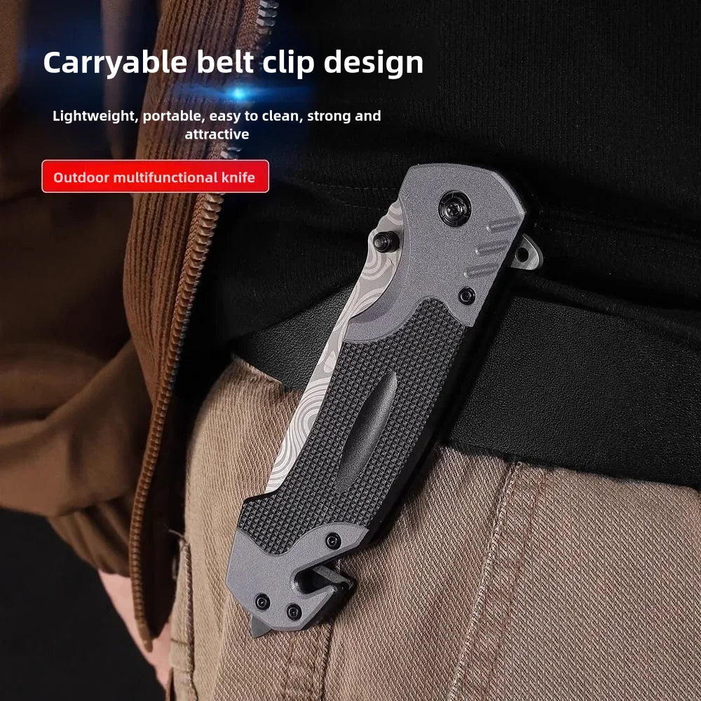 A close-up of a black multi-functional folding survival knife clipped onto a brown jacket.