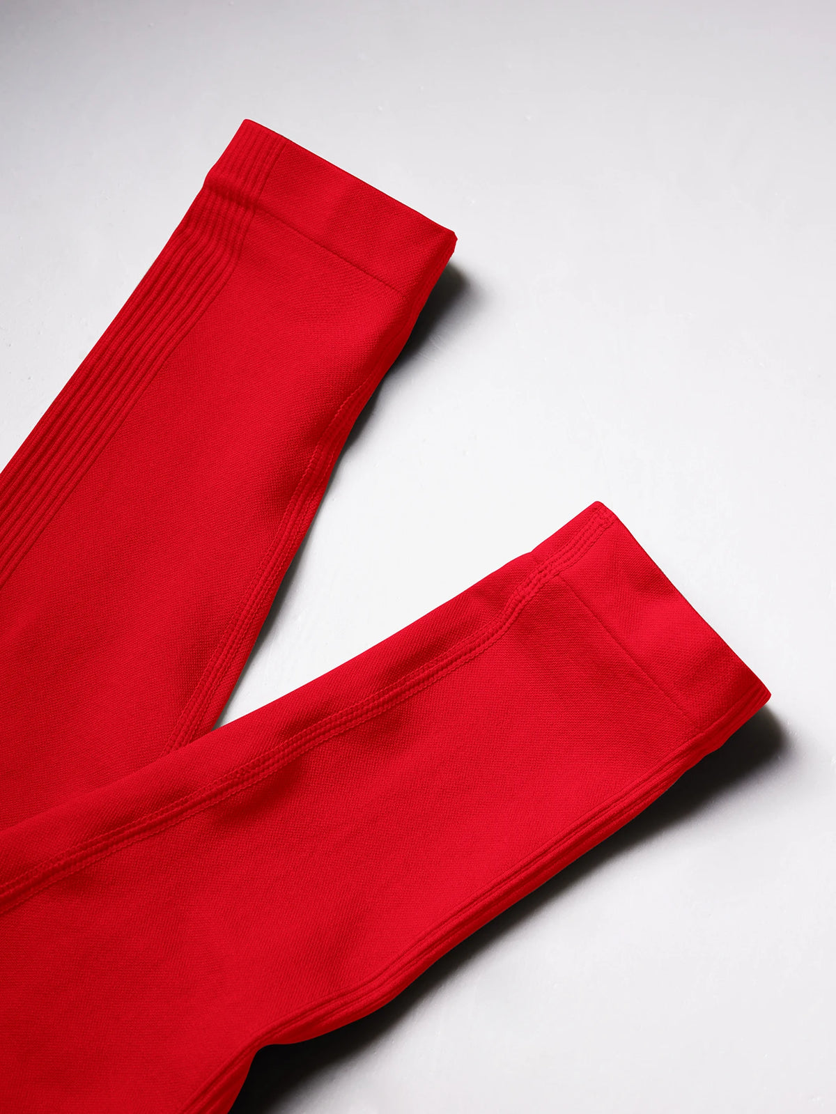 Leuchtend rote, hoch taillierte, nahtlose Yoga-Leggings auf weißem Hintergrund.