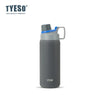 A matte gray insulated stainless steel water bottle with a blue cap and carrying loop.