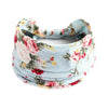 A light blue cotton stretch headband with a floral print featuring pink and red roses.
