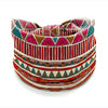 A close-up of a bohemian stretch cotton headband featuring geometric patterns in pink, teal, and red stripes.