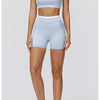Eine Frau modelliert ein hellblaues Yoga- und Gym-Trainingsanzug-Set mit Crop-Top und passenden Shorts.