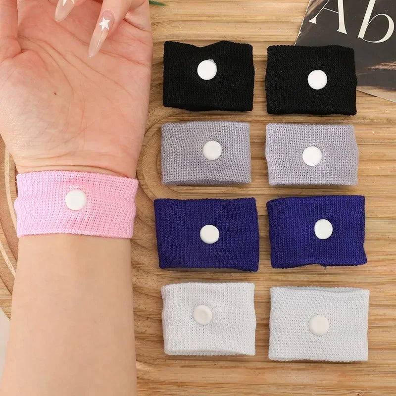 A collection of various colored wristbands for anti-nausea relief, including black, gray, purple, and white.