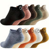 An assortment of eight low-cut ankle socks in various muted colors with smiling embroidery