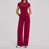A woman wearing a maroon women's premium fitness tracksuit top and pants.