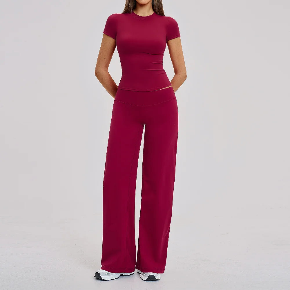 A woman wearing a maroon women's premium fitness tracksuit top and pants.