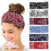 A woman wearing a maroon bohemian print wide headband with a pink flower.