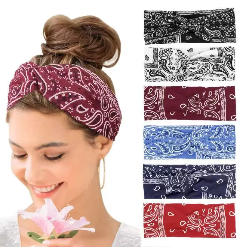 A woman wearing a maroon bohemian print wide headband with a pink flower.