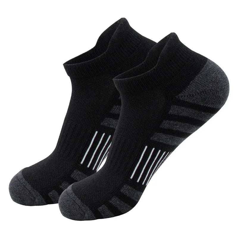 A pair of black athletic running socks with light gray stripes on the foot.