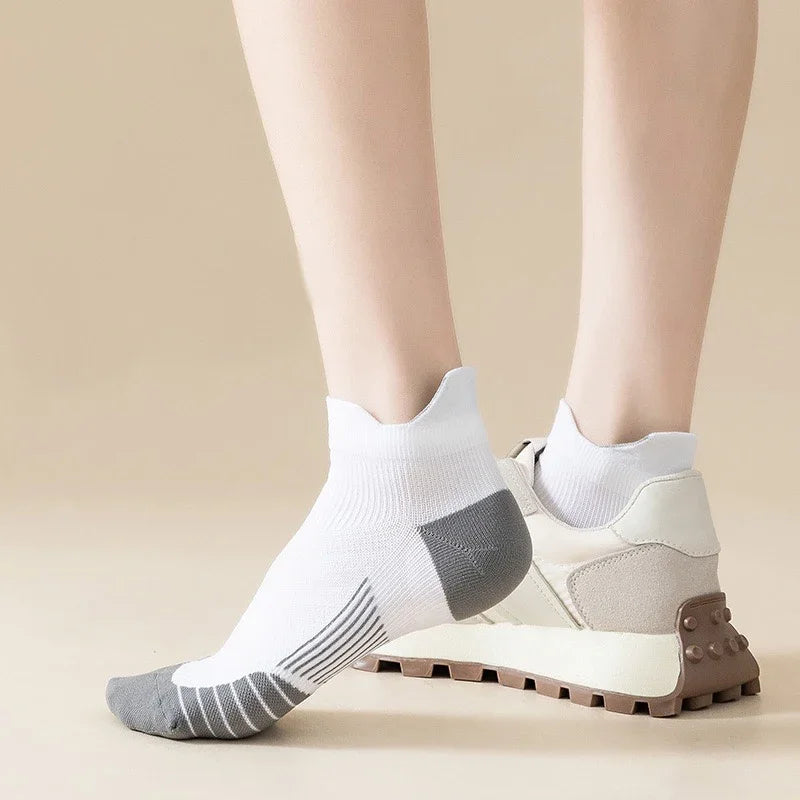 White performance compression sports socks worn on a person's ankle and foot.
