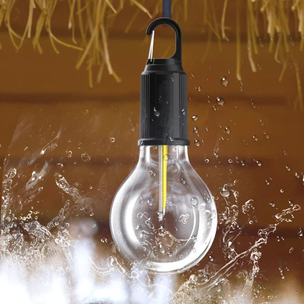 A yellow LED light bulb is being dropped into water, illustrating the performance of a USB rechargeable camping lantern.