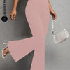 A model wearing light pink flared yoga trousers and a white shoulder bag.