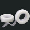 Roll of transparent fabric eyelash extension tape with a dispenser strip