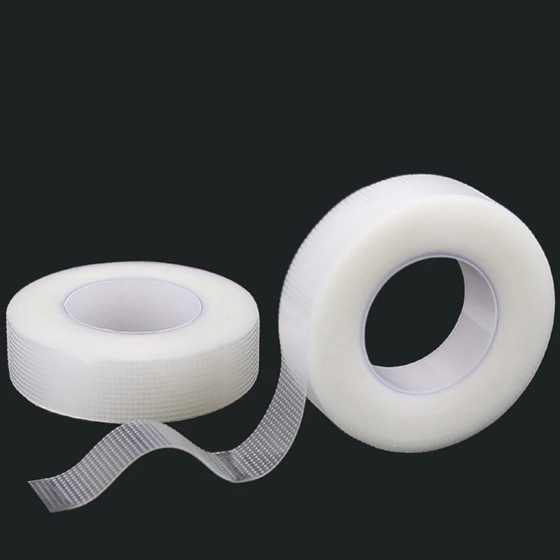 Roll of transparent fabric eyelash extension tape with a dispenser strip