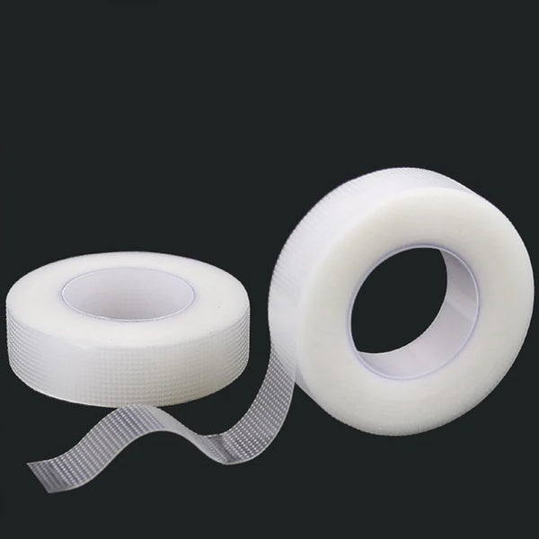 Roll of transparent fabric eyelash extension tape with a dispenser strip