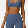 A woman wearing a solid blue high-support sports bra and matching athletic shorts.