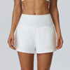 Eine Frau modelliert weiße sportliche Quick-Dry-Shorts von hinten.