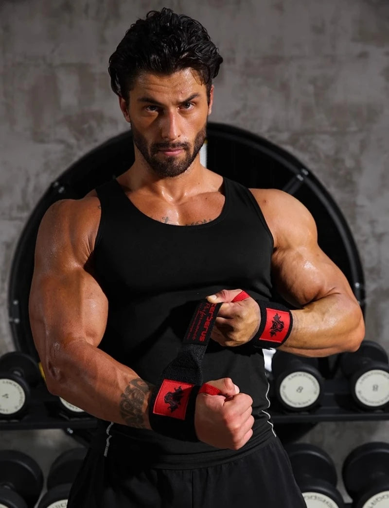 Un homme musclé portant un débardeur noir et des bandes de poignet fait une pose dans une salle de sport.