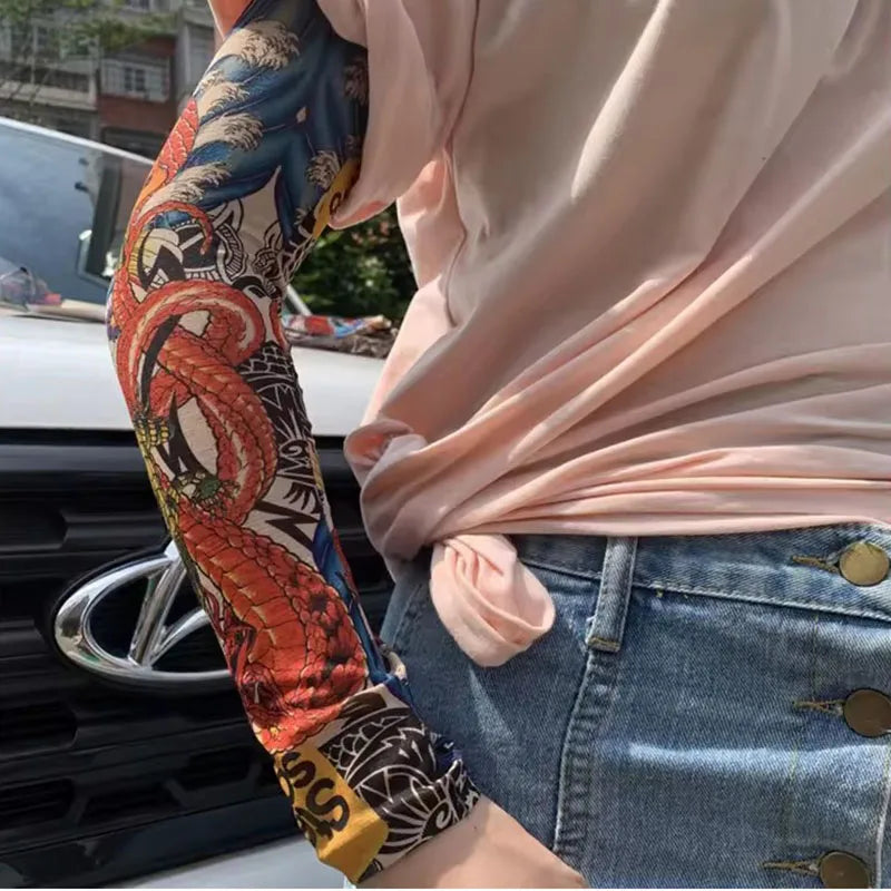 Una persona con una blusa rosa muestra una manga de brazo estampada en naranja y negro en su antebrazo.