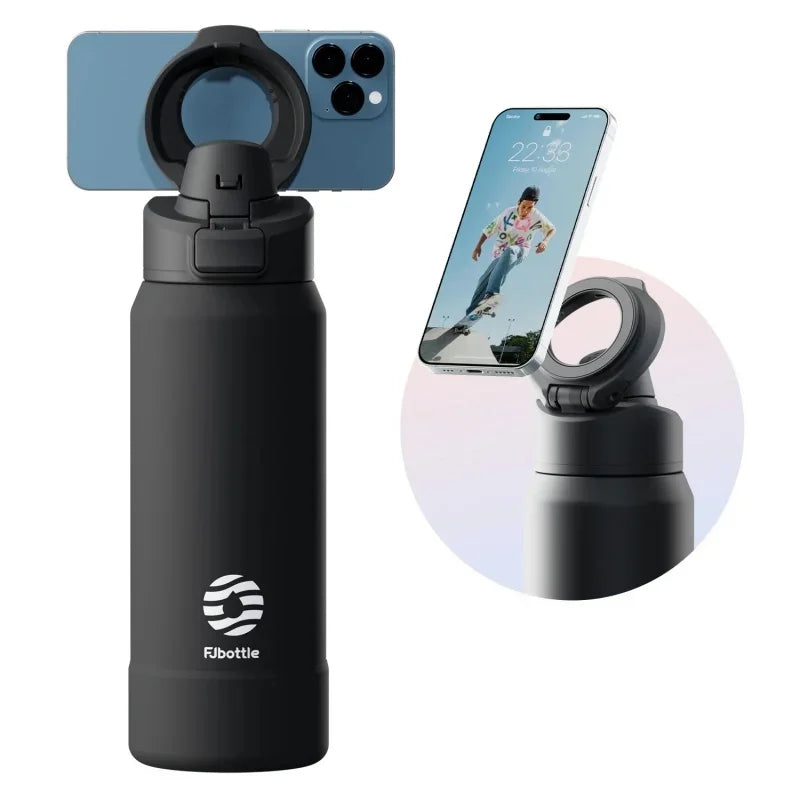 A black insulated sports water bottle with a magnetic lid shown next to an iPhone.