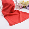 Serviette de refroidissement rouge corail circulaire drapée à côté d'un vélo et d'un arrangement floral.