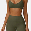 A model wearing a olive green high-support sports bra and matching high-waisted shorts.