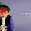 A child wearing orange polarized sports sunglasses and a grey cap is shown against a purple background.