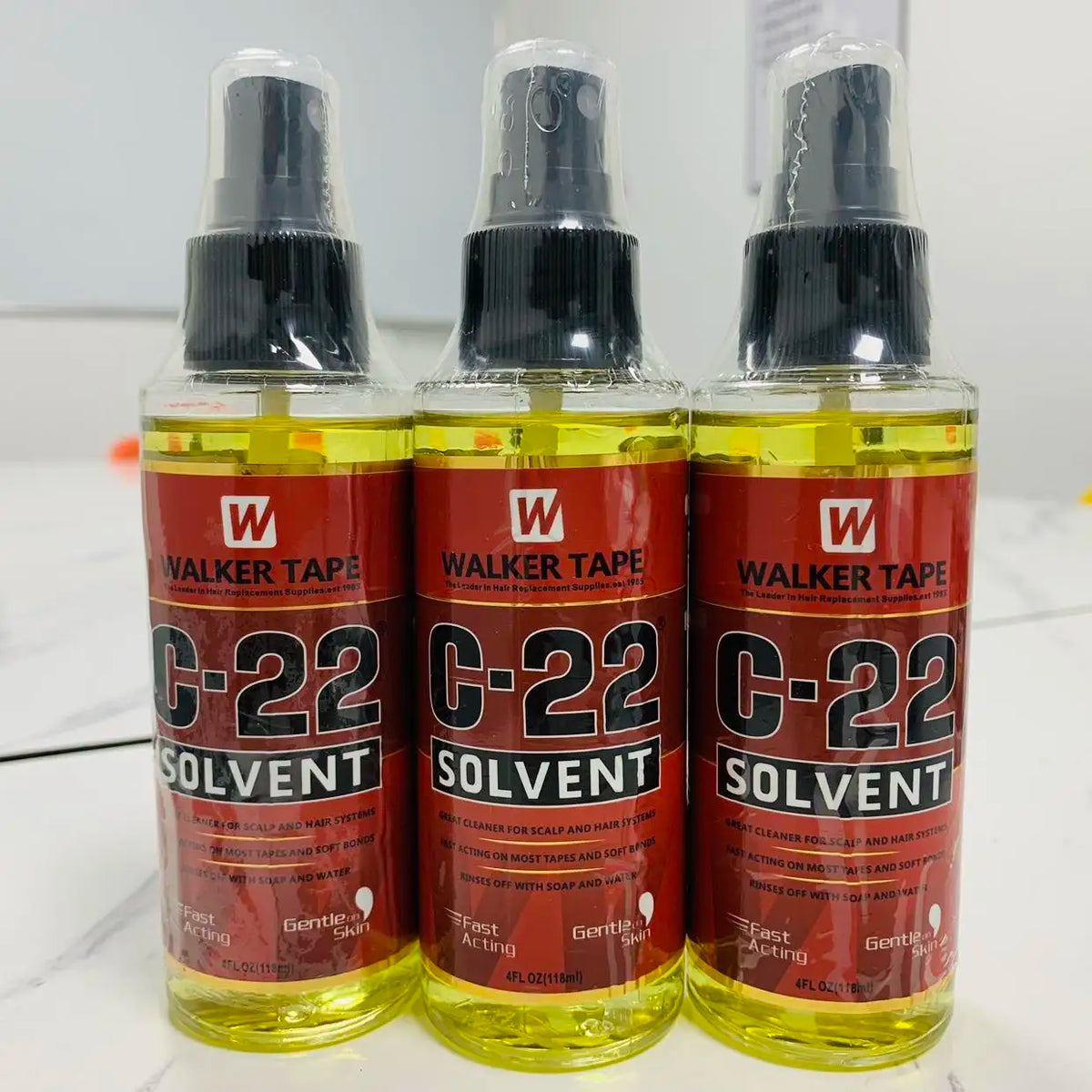 Three bottles of Walker Tape C-22 Solvent liquid in glass containers